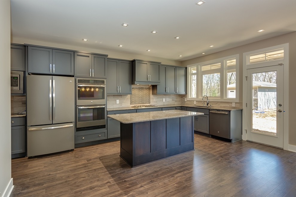 Design ideas for a contemporary eat-in kitchen in Grand Rapids with an undermount sink, shaker cabinets, grey cabinets, solid surface benchtops, grey splashback, ceramic splashback, coloured appliances, medium hardwood floors and with island.