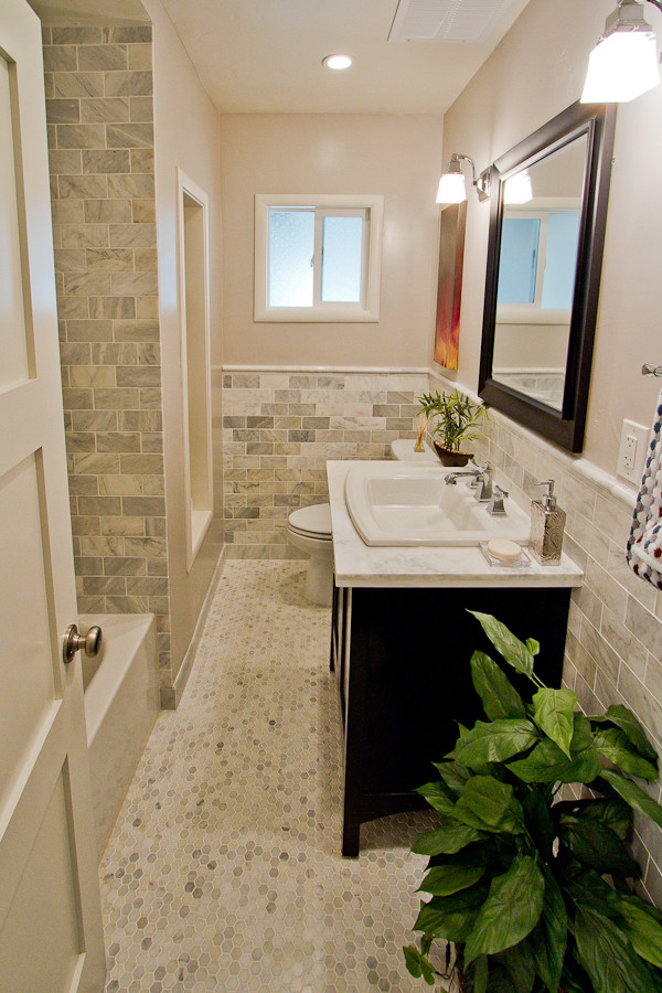 This is an example of a mid-sized contemporary bathroom in Sacramento with a drop-in sink, furniture-like cabinets, black cabinets, marble benchtops, an alcove tub, a shower/bathtub combo, a two-piece toilet, gray tile, subway tile, grey walls and marble floors.