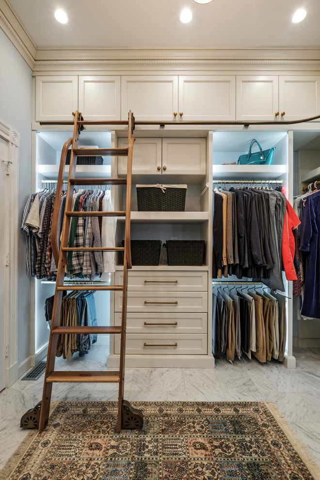 Photo of a traditional gender-neutral walk-in wardrobe in Other with recessed-panel cabinets, beige cabinets and grey floor.