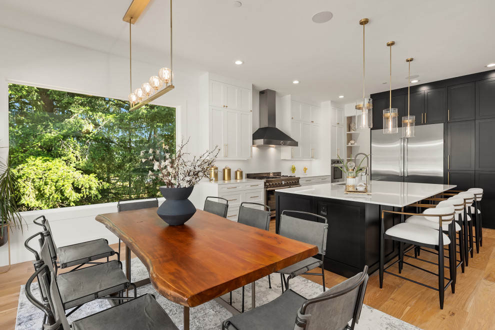 Design ideas for a large classic galley open plan kitchen in Seattle with a submerged sink, shaker cabinets, white cabinets, engineered stone countertops, white splashback, engineered quartz splashback, stainless steel appliances, light hardwood flooring, an island and white worktops.