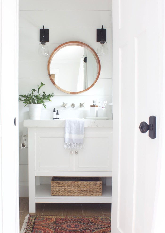 Design ideas for a small beach style master bathroom in Orlando with shaker cabinets, white cabinets, an alcove shower, a one-piece toilet, white walls, ceramic floors, engineered quartz benchtops, brown floor and a shower curtain.