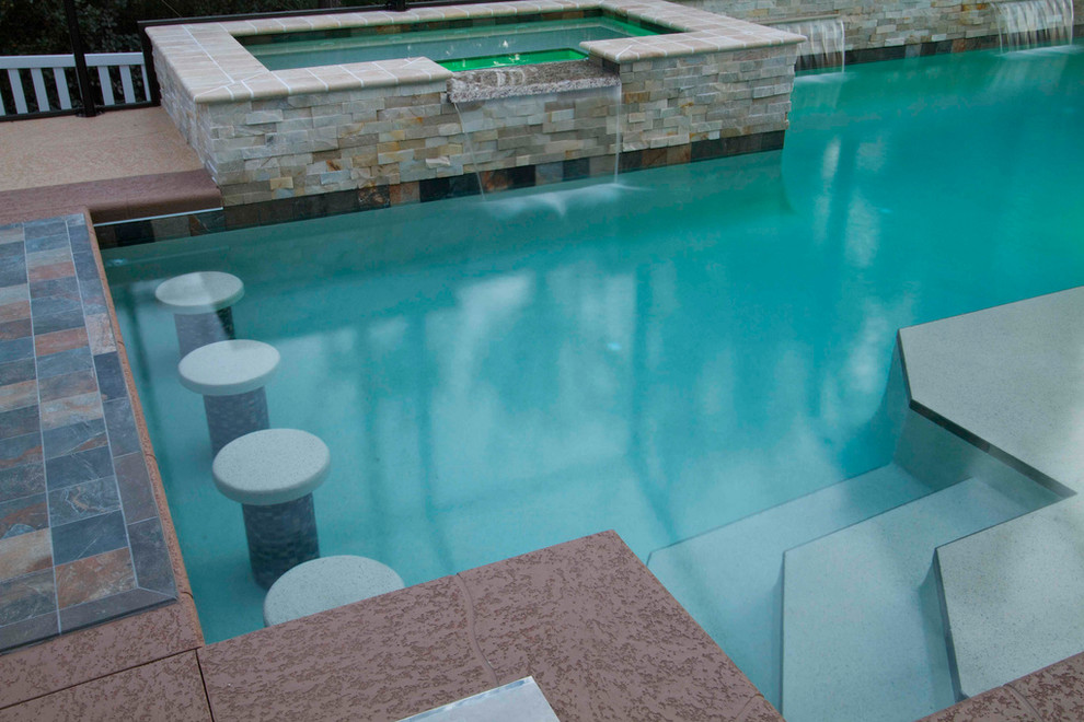 Example of a large backyard stone and custom-shaped natural hot tub design in Jacksonville