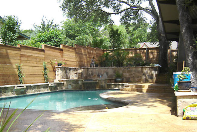 Photo of a large arts and crafts backyard custom-shaped lap pool in Austin with a hot tub and natural stone pavers.