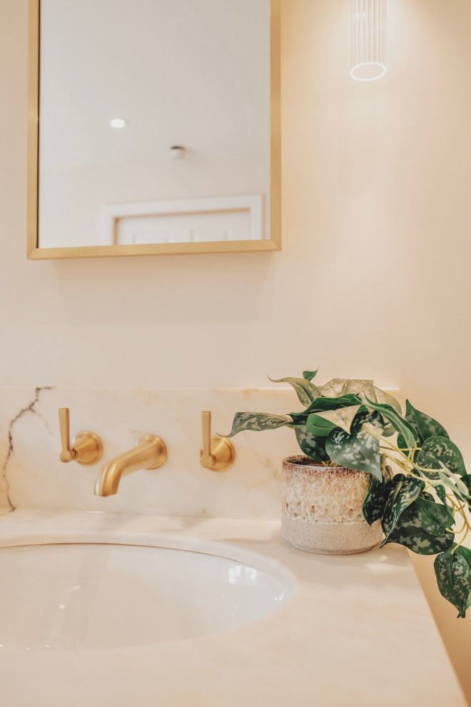 На фото: большая главная ванная комната в классическом стиле с фасадами в стиле шейкер, белыми фасадами, отдельно стоящей ванной, душевой комнатой, инсталляцией, бежевой плиткой, мраморной плиткой, бежевыми стенами, мраморным полом, накладной раковиной, мраморной столешницей, бежевым полом, душем с распашными дверями, розовой столешницей, нишей, тумбой под две раковины и напольной тумбой