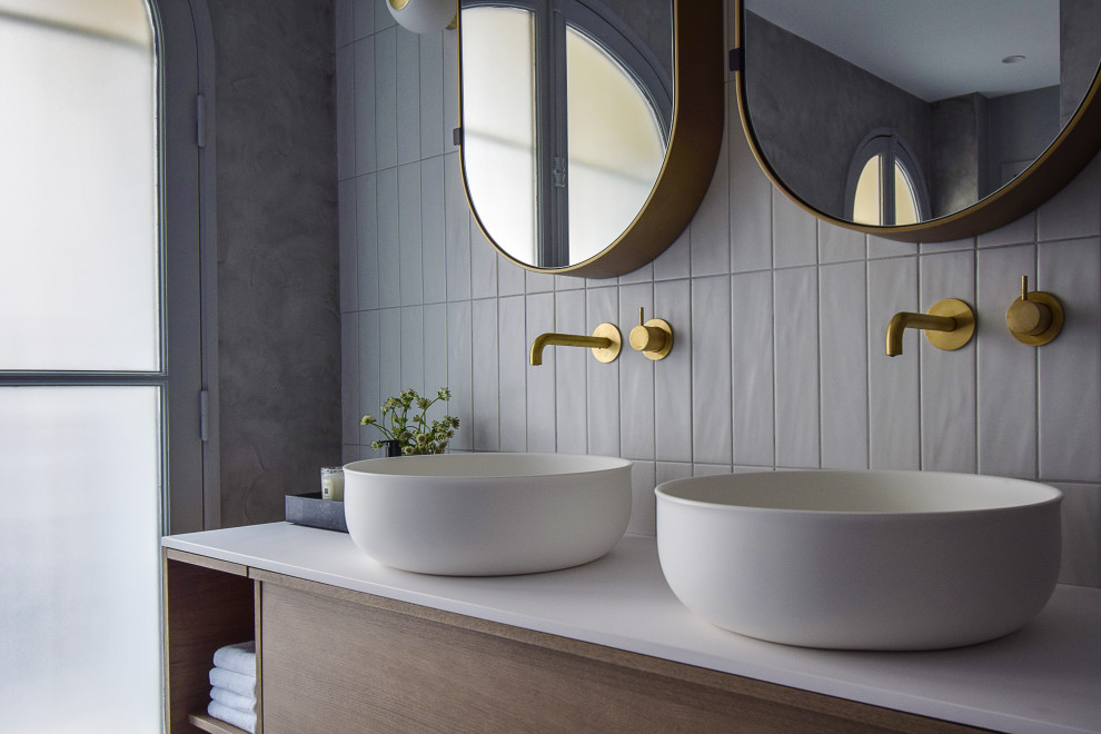 This is an example of a mid-sized contemporary master bathroom in Paris with medium wood cabinets, a curbless shower, white tile, porcelain tile, white walls, a drop-in sink, solid surface benchtops, white benchtops, a double vanity and a built-in vanity.