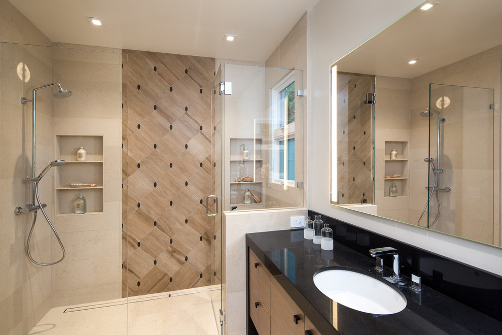 Photo of a large contemporary master bathroom in San Francisco with flat-panel cabinets, light wood cabinets, beige tile, white walls, a drop-in sink, engineered quartz benchtops, porcelain tile, porcelain floors, a curbless shower, beige floor and a hinged shower door.