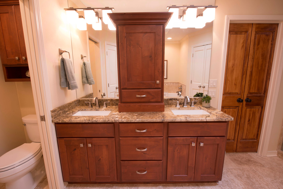 Transitional bathroom in New Orleans with an undermount sink, recessed-panel cabinets, dark wood cabinets, granite benchtops, an alcove shower, a two-piece toilet, beige tile and ceramic tile.