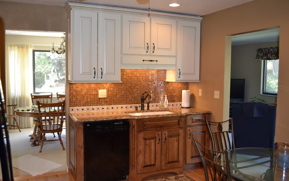 Mid-sized transitional l-shaped light wood floor eat-in kitchen photo in Denver with an undermount sink, raised-panel cabinets, distressed cabinets, quartz countertops, brown backsplash, glass sheet backsplash, black appliances and an island