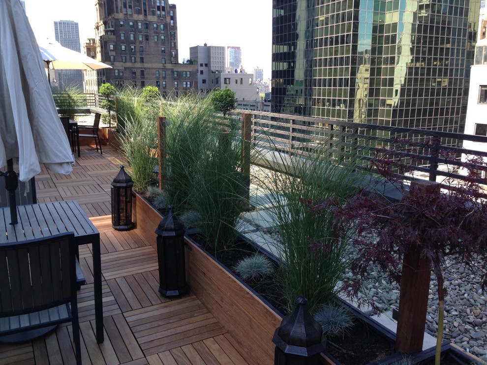Photo of an expansive contemporary rooftop deck in New York with a container garden and an awning.