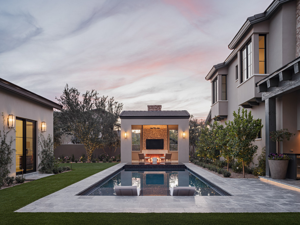 Modelo de piscina alargada minimalista pequeña rectangular en patio trasero con paisajismo de piscina y suelo de baldosas