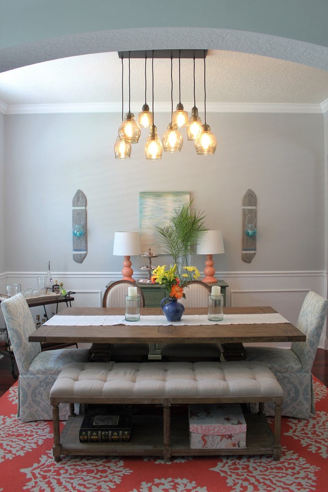 This is an example of a mid-sized beach style separate dining room in New Orleans with grey walls, dark hardwood floors and no fireplace.