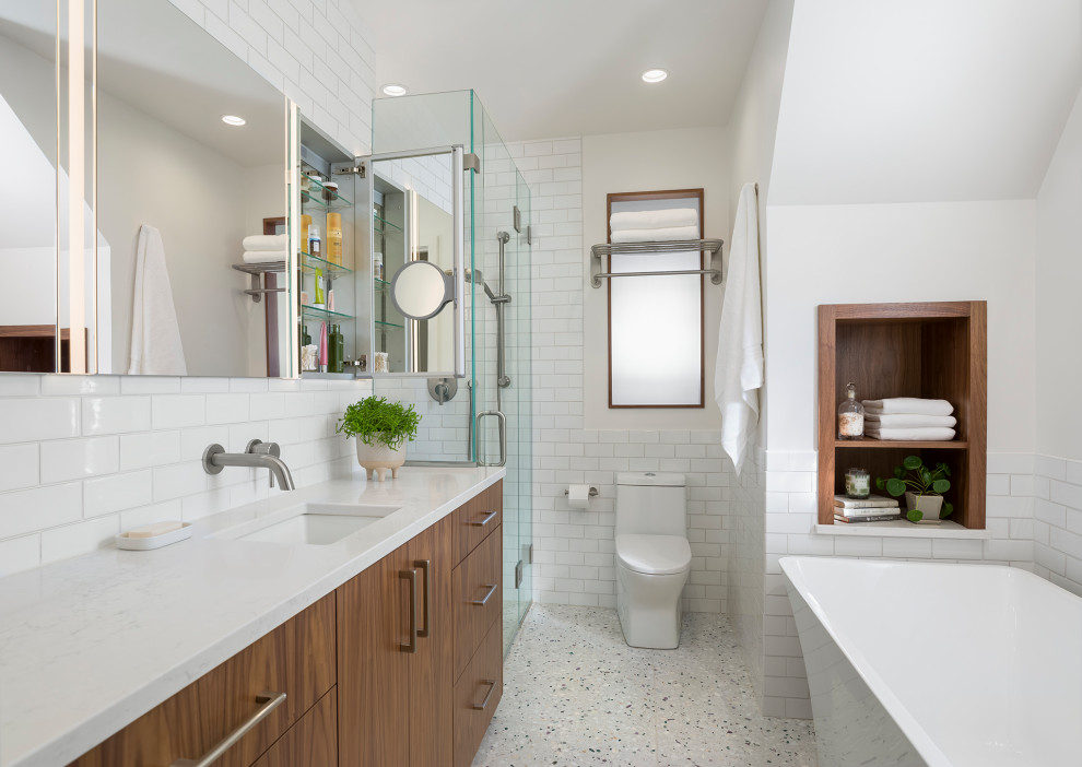 Design ideas for a small modern master bathroom in Minneapolis with flat-panel cabinets, medium wood cabinets, a freestanding tub, a corner shower, a one-piece toilet, white tile, ceramic tile, white walls, pebble tile floors, an undermount sink, engineered quartz benchtops, white floor, a hinged shower door, white benchtops, a niche, a single vanity and a built-in vanity.