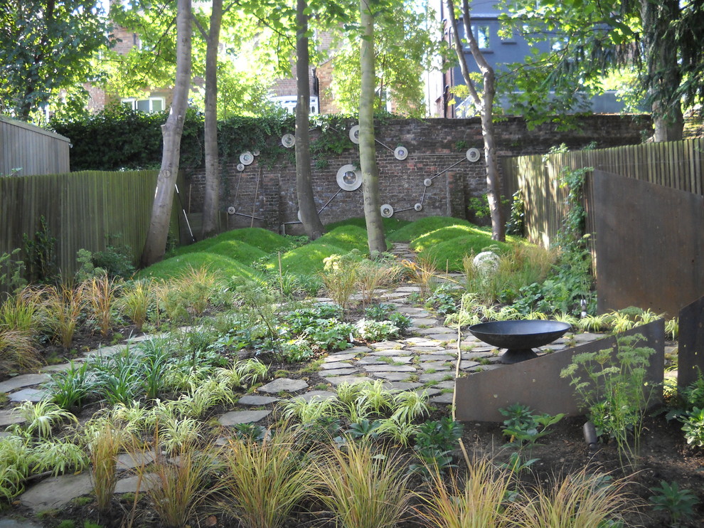 Inspiration for an eclectic backyard garden in London with a fire feature.