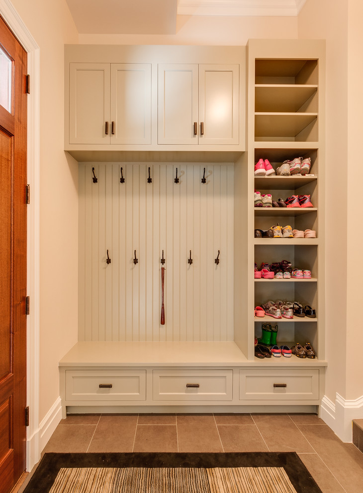 Inspiration for a mid-sized traditional mudroom in Other with white walls, ceramic floors, a pivot front door and a medium wood front door.