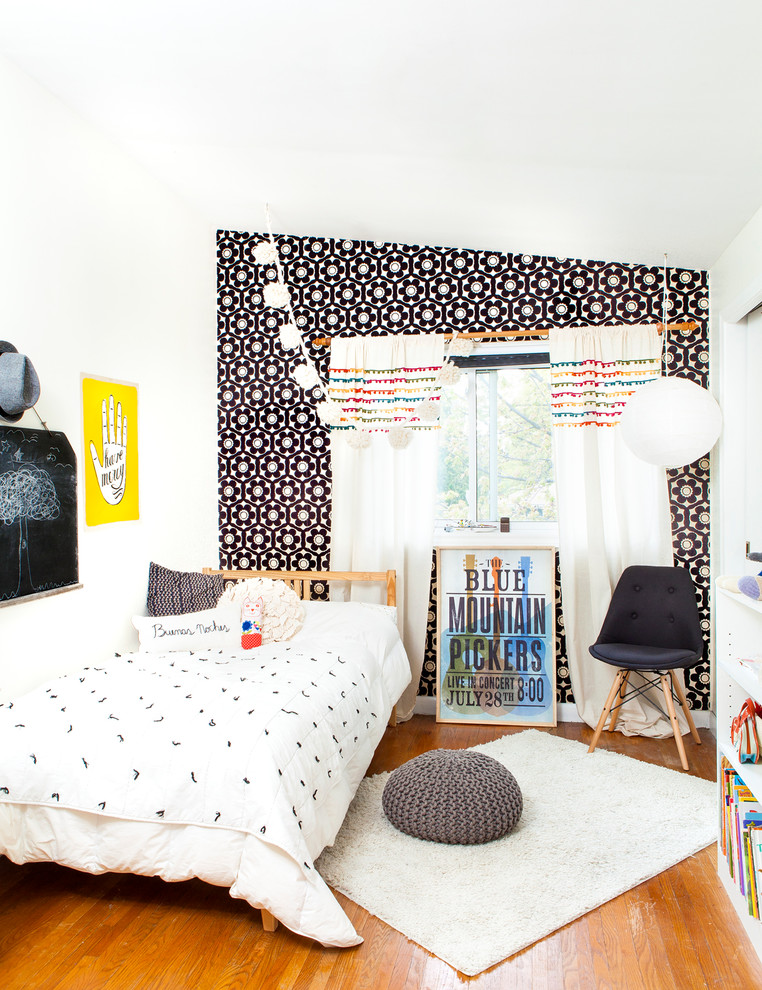 Design ideas for a contemporary kids' room for girls in Toronto with black walls, medium hardwood floors and brown floor.