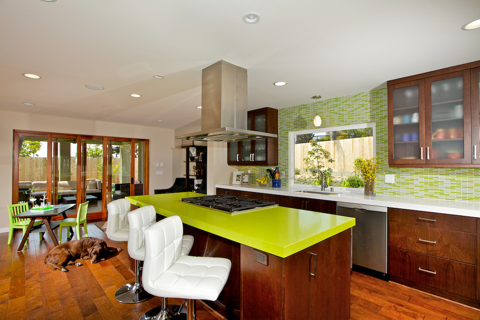 Photo of a contemporary eat-in kitchen in San Diego with glass-front cabinets, matchstick tile splashback, dark wood cabinets, green splashback and green benchtop.