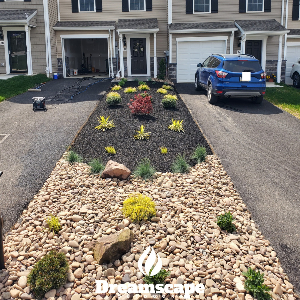 Photo of a small traditional front driveway partial sun garden for summer in Other with a flowerbed and concrete paving.