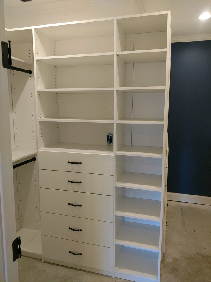 This is an example of a small contemporary gender-neutral walk-in wardrobe in Louisville with open cabinets, white cabinets, concrete floors and brown floor.