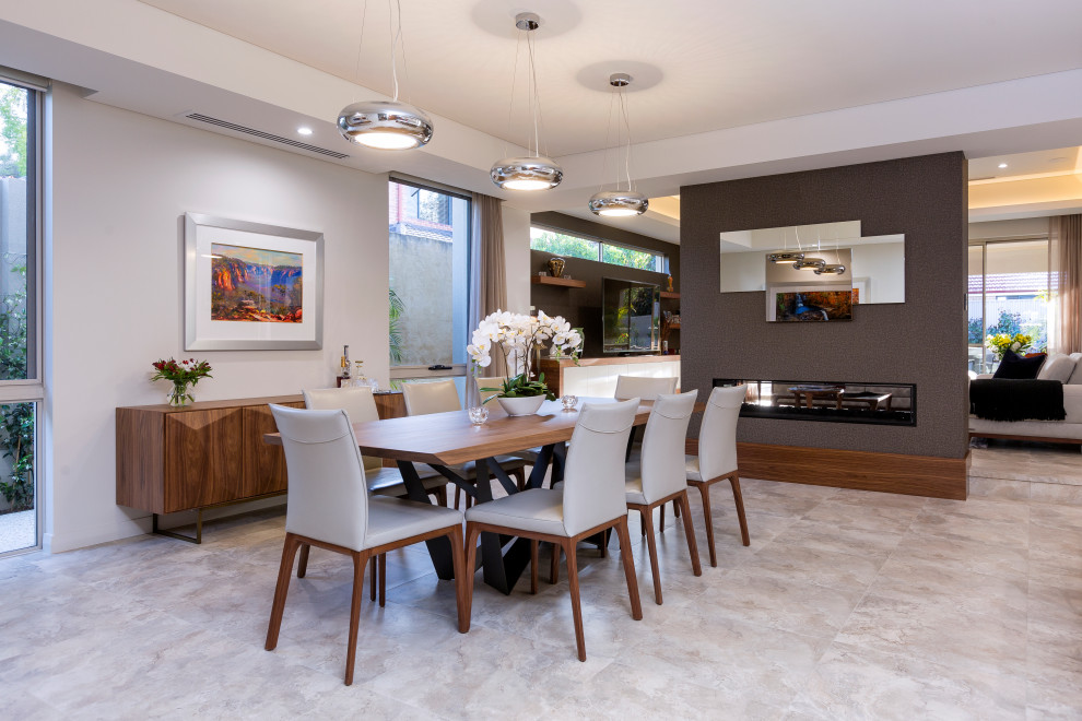 Exemple d'une salle à manger ouverte sur le salon tendance de taille moyenne avec un mur gris, tomettes au sol, une cheminée double-face, un manteau de cheminée en plâtre, un sol beige et du papier peint.