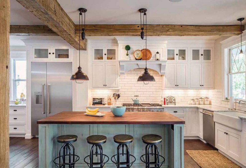 Photo of a mid-sized country l-shaped kitchen in Other with a farmhouse sink, shaker cabinets, white cabinets, wood benchtops, white splashback, subway tile splashback, stainless steel appliances, dark hardwood floors, with island, brown floor and brown benchtop.