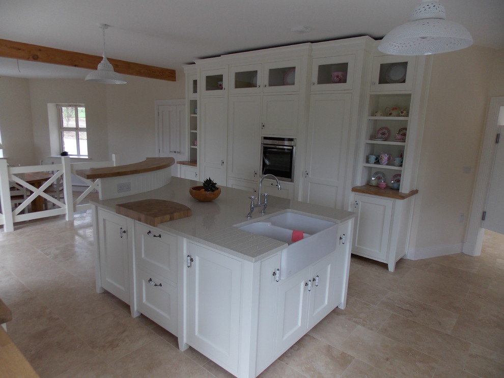 Design ideas for an expansive traditional u-shaped eat-in kitchen in Dublin with a farmhouse sink, beaded inset cabinets, white cabinets, wood benchtops, travertine floors and with island.