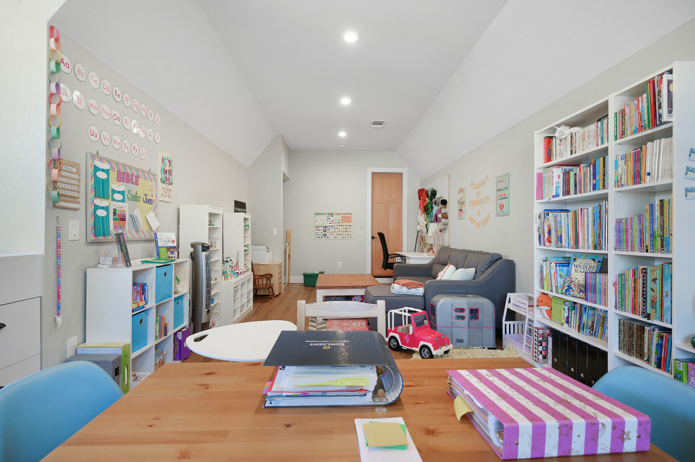 Bild på ett stort lantligt barnrum kombinerat med lekrum, med vita väggar, mellanmörkt trägolv och brunt golv