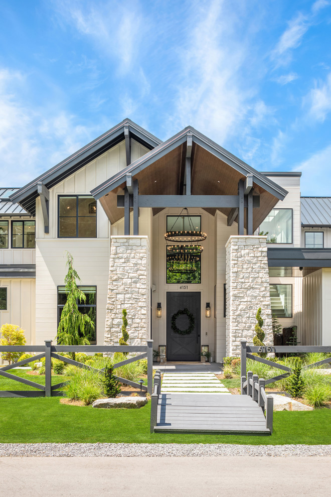 Großes, Dreistöckiges Klassisches Einfamilienhaus mit Mix-Fassade, beiger Fassadenfarbe, Satteldach, Blechdach, schwarzem Dach und Wandpaneelen in Seattle