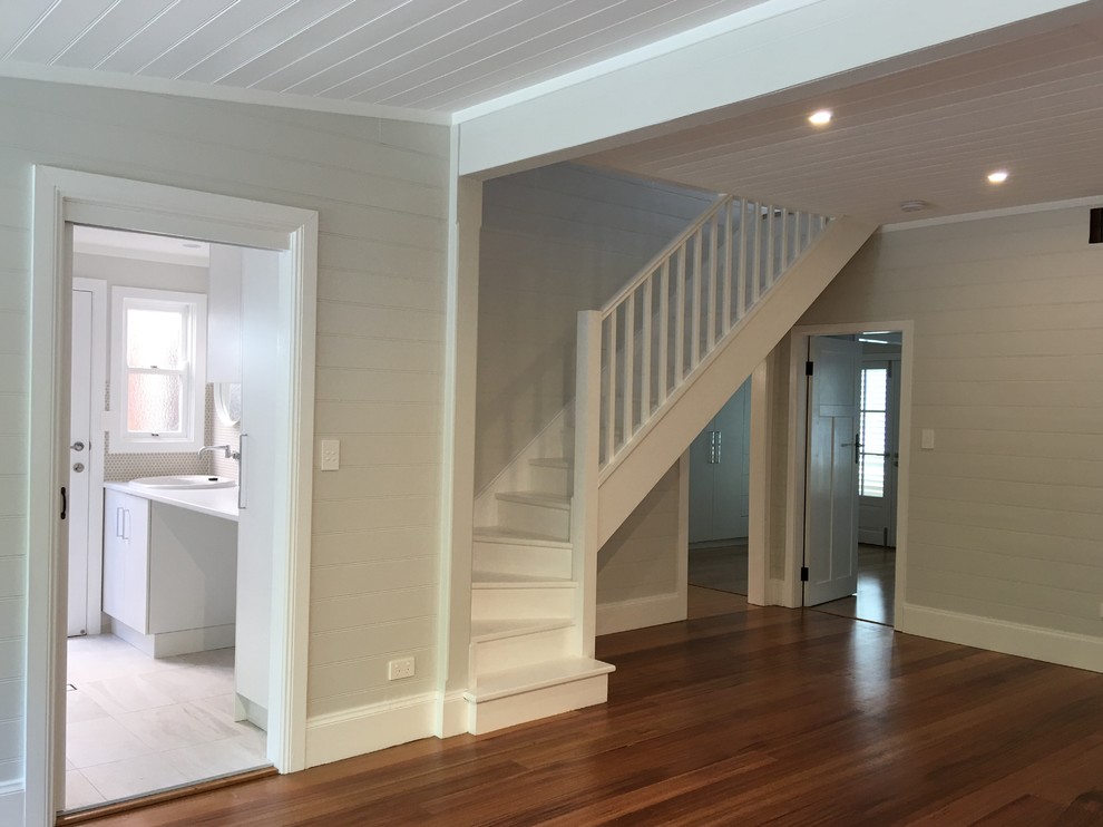 This is an example of a small contemporary painted wood curved staircase in Wollongong with painted wood risers and wood railing.