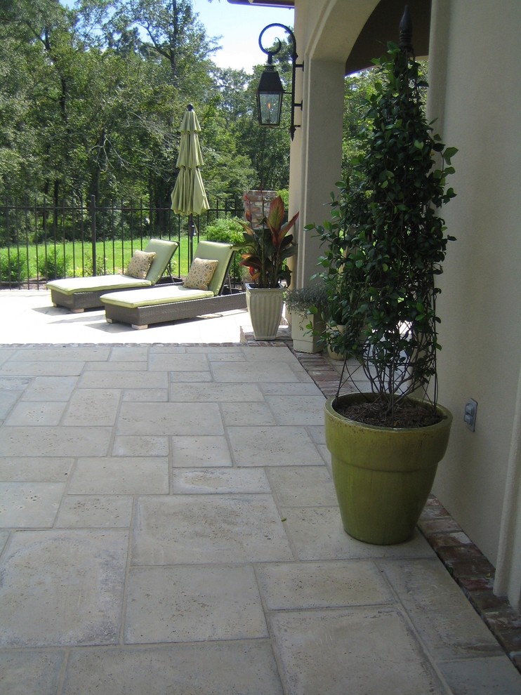 Design ideas for a mid-sized mediterranean backyard patio in Miami with concrete pavers and a roof extension.