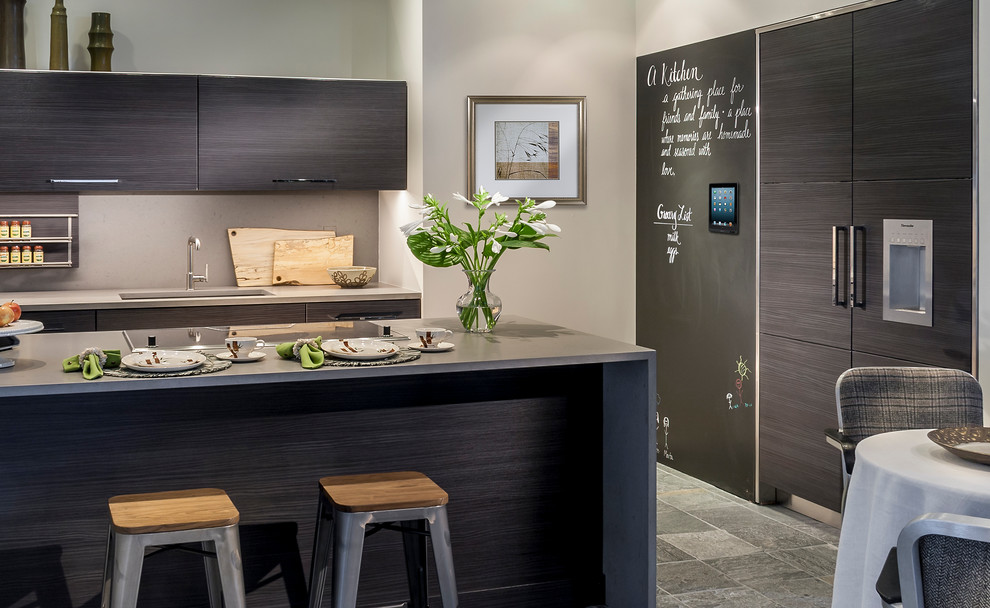 Mid-sized contemporary galley separate kitchen in Chicago with an undermount sink, flat-panel cabinets, dark wood cabinets, quartz benchtops, grey splashback, stone slab splashback, panelled appliances, slate floors and a peninsula.