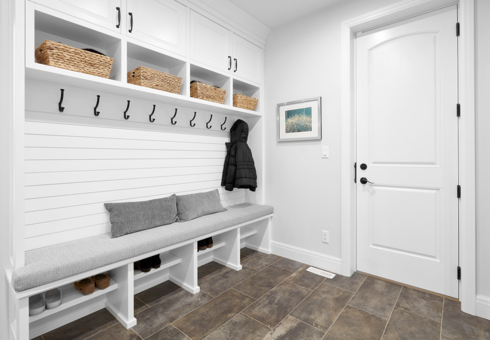 Design ideas for a mid-sized transitional mudroom in Edmonton with ceramic floors, a single front door and brown floor.