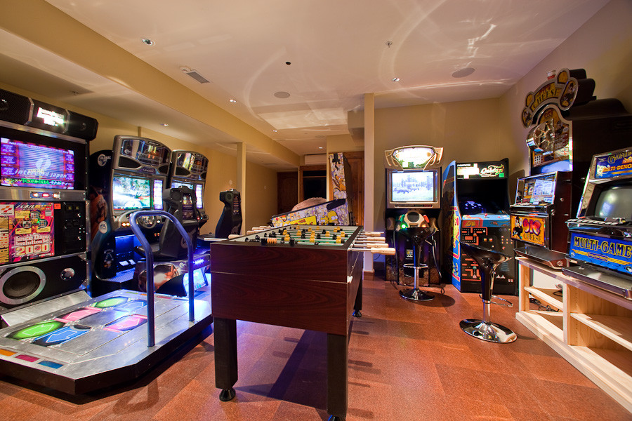 This is an example of a large country family room in Denver with beige walls, cork floors and a game room.