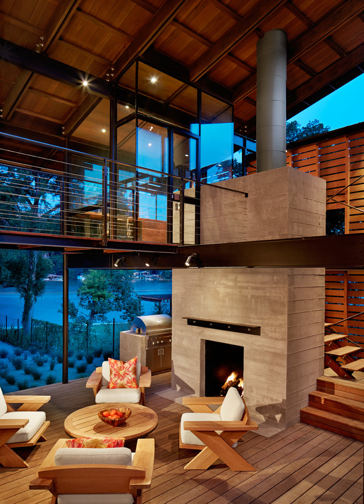 This is an example of a large contemporary patio in Austin with decking, a roof extension and with fireplace.