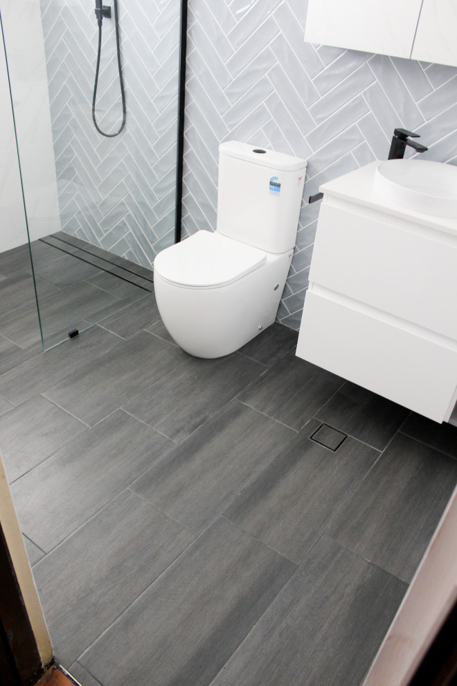 Inspiration for a medium sized modern shower room bathroom in Perth with flat-panel cabinets, white cabinets, a walk-in shower, a one-piece toilet, blue walls, porcelain flooring, a vessel sink, copper worktops, black floors, an open shower, white worktops, a single sink and a floating vanity unit.