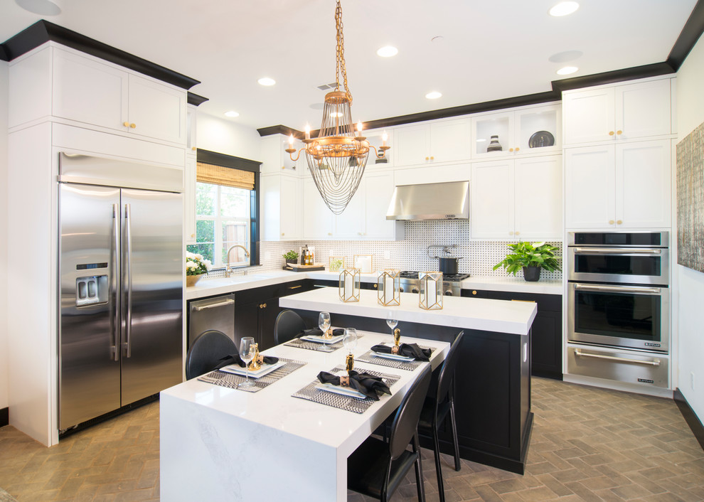 This is an example of a transitional l-shaped eat-in kitchen in San Francisco with shaker cabinets, multi-coloured splashback, stainless steel appliances, brick floors, with island and brown floor.