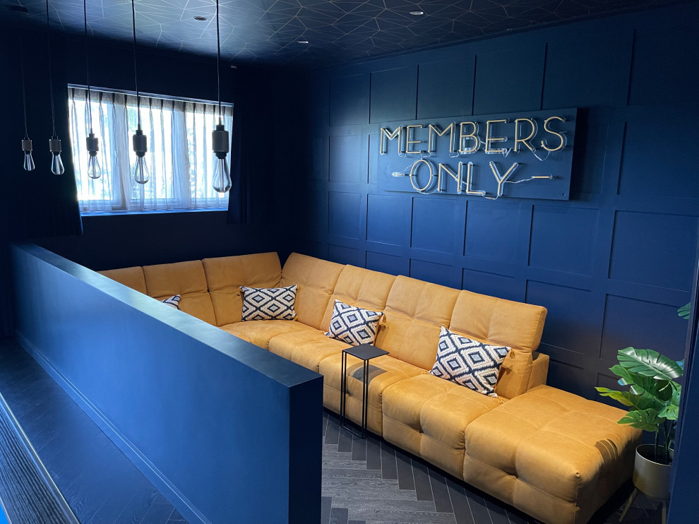 Foto di un piccolo soggiorno minimalista aperto con angolo bar, pareti blu, pavimento in laminato, TV a parete, pavimento nero, soffitto in carta da parati e pannellatura
