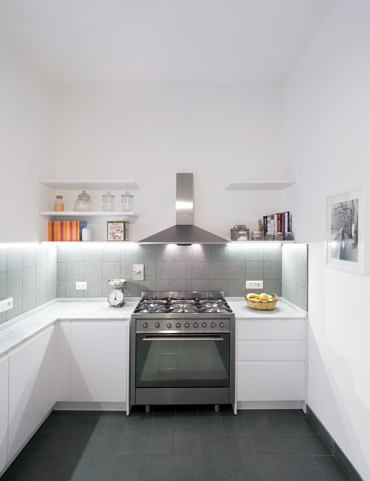 Photo of a small contemporary l-shaped kitchen in Rome with flat-panel cabinets, white cabinets, marble benchtops, grey splashback, ceramic splashback, stainless steel appliances and ceramic floors.