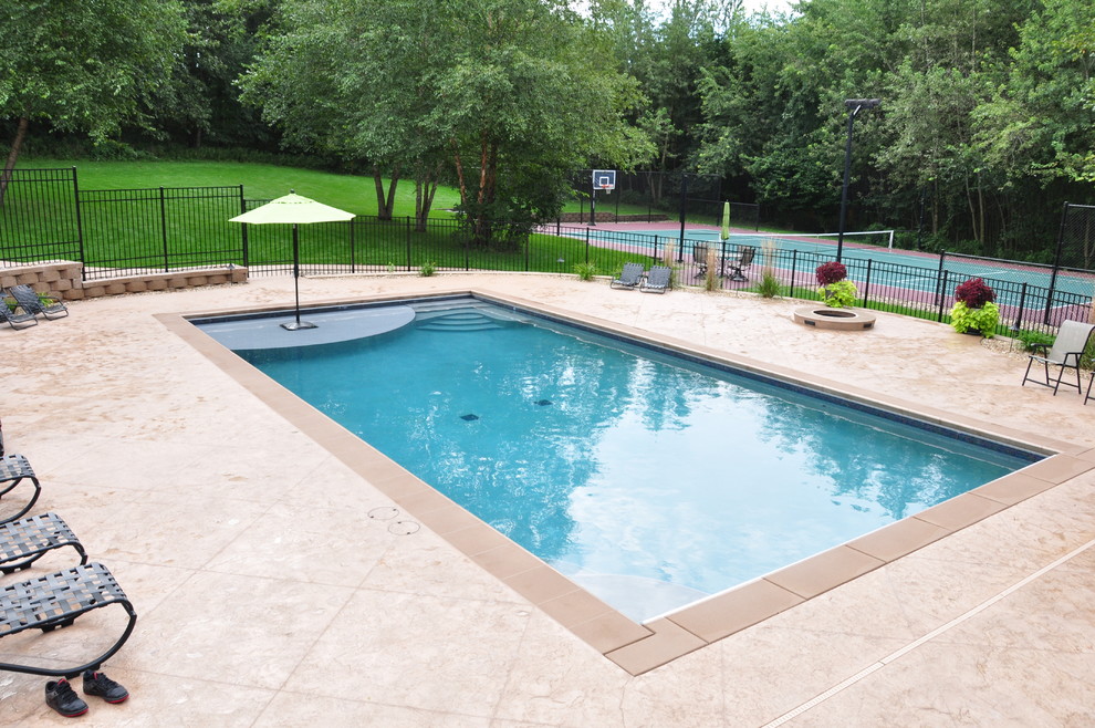 Large traditional rectangular pool in Cedar Rapids with stamped concrete.