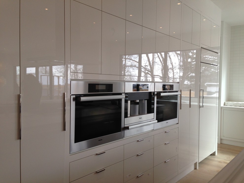 Inspiration for a large modern l-shaped eat-in kitchen remodel in Calgary with flat-panel cabinets, white cabinets, quartz countertops, stainless steel appliances and two islands