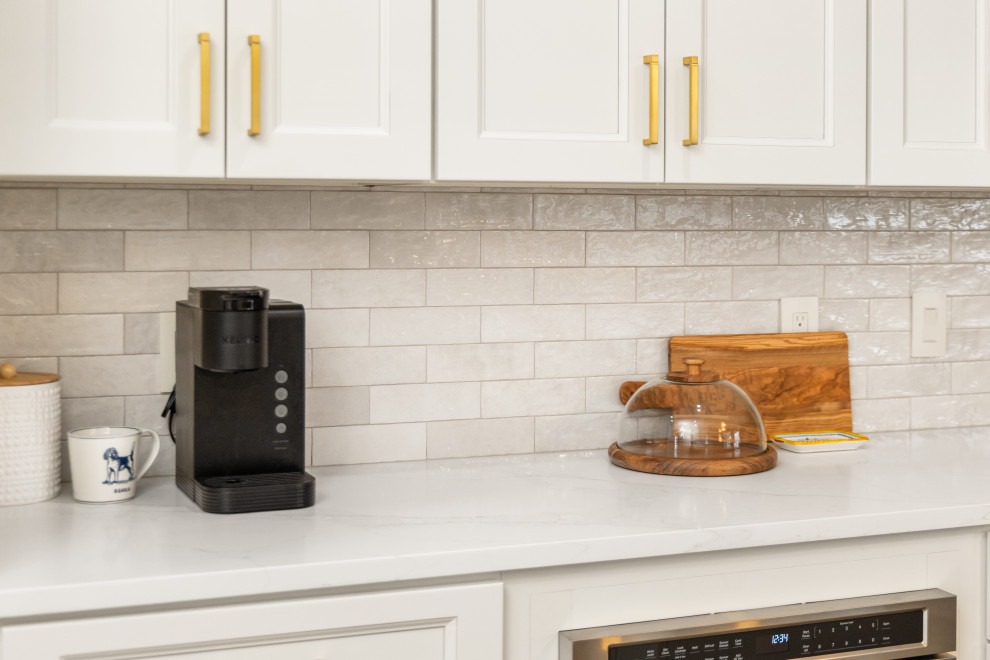 Example of a small transitional l-shaped light wood floor and multicolored floor eat-in kitchen design in Tampa with an undermount sink, shaker cabinets, beige cabinets, quartzite countertops, beige backsplash, porcelain backsplash, stainless steel appliances, a peninsula and white countertops