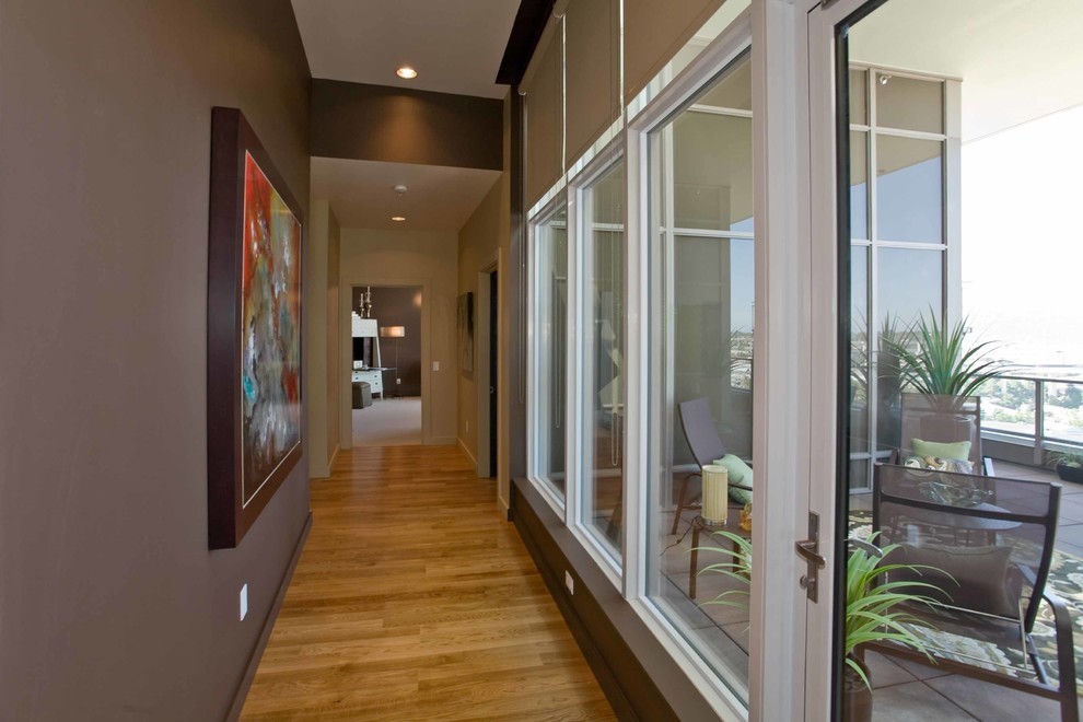 This is an example of a mid-sized contemporary hallway in Portland with brown walls and medium hardwood floors.
