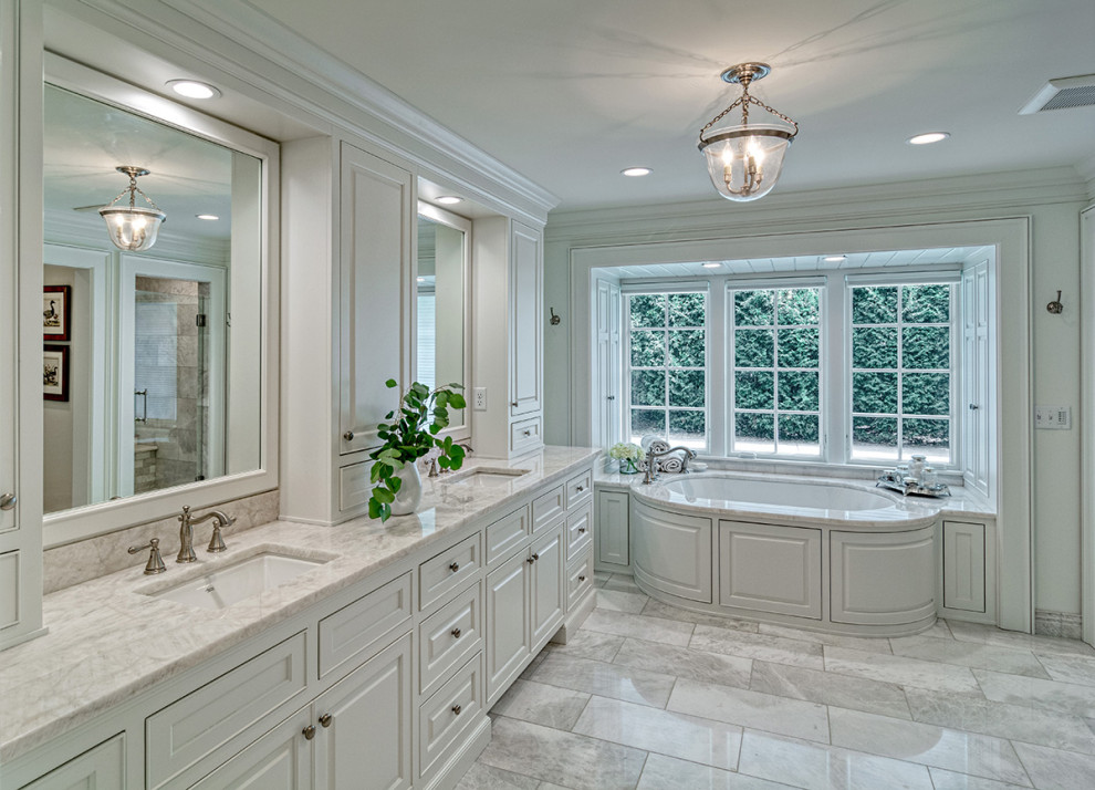 Photo of a large traditional master bathroom in Minneapolis with recessed-panel cabinets, white cabinets, an undermount tub, an alcove shower, a one-piece toilet, gray tile, grey walls, ceramic floors, an undermount sink, quartzite benchtops, grey floor, a hinged shower door, white benchtops, an enclosed toilet, a double vanity and a built-in vanity.