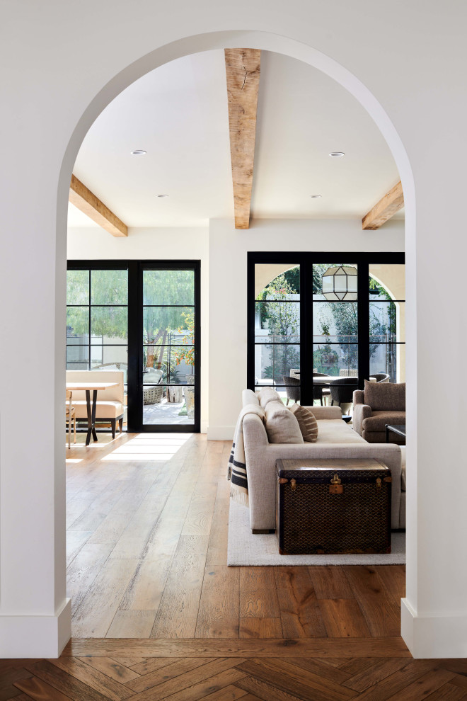 Foto de salón con barra de bar abierto minimalista de tamaño medio con paredes blancas, suelo de madera en tonos medios, televisor colgado en la pared, suelo beige y vigas vistas