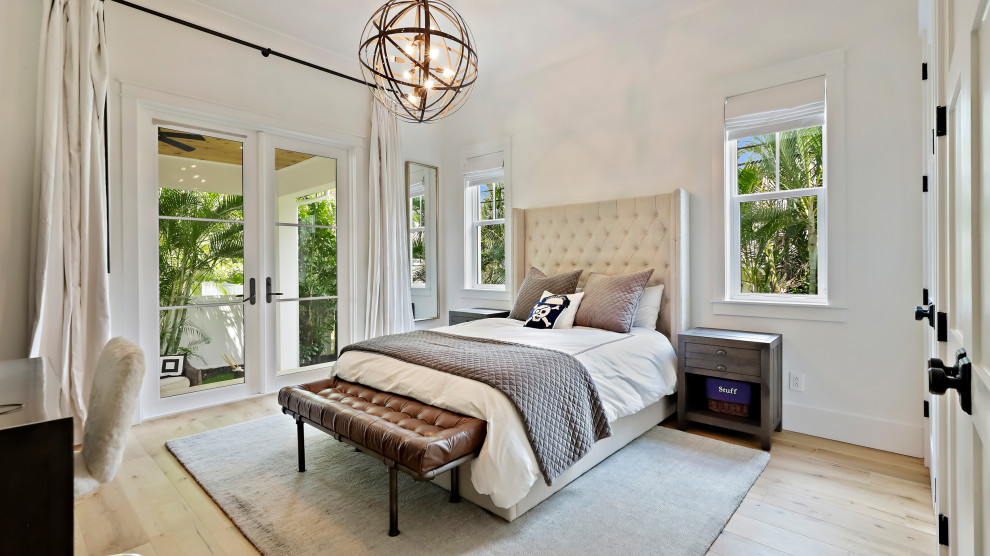 This is an example of a large transitional master bedroom in Tampa with white walls, medium hardwood floors and beige floor.
