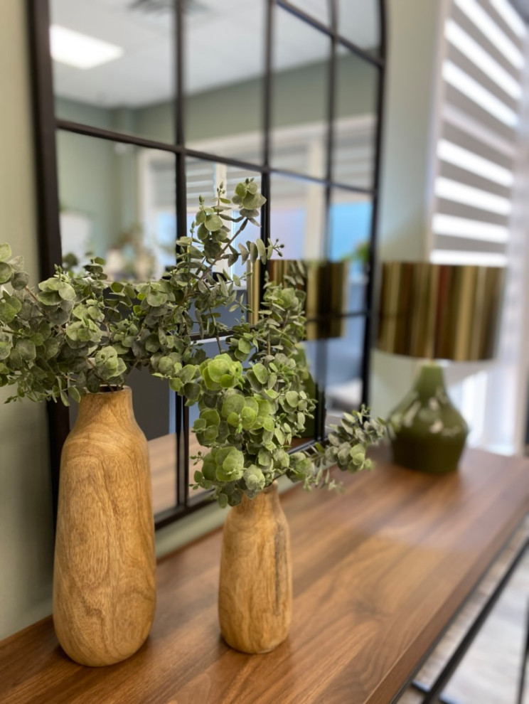 A warm entry with a lovely console table, industrial mirror and unique lamp set the mood for this law office.