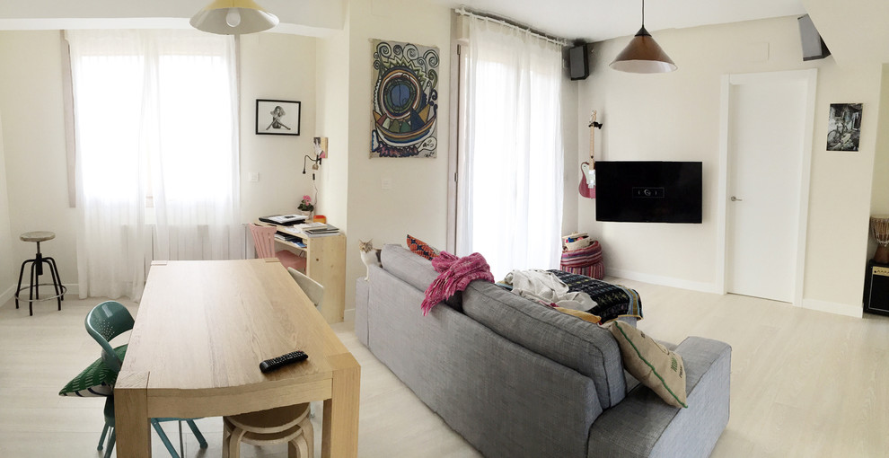 Modelo de salón para visitas abierto nórdico de tamaño medio sin chimenea con suelo de madera clara y televisor colgado en la pared