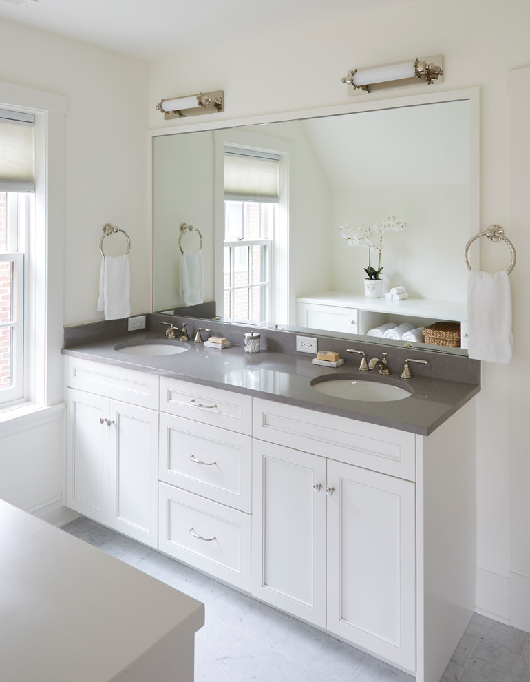 This is an example of a mid-sized transitional 3/4 bathroom in Chicago with recessed-panel cabinets, white cabinets, white walls, ceramic floors, an undermount sink, engineered quartz benchtops, white floor and grey benchtops.