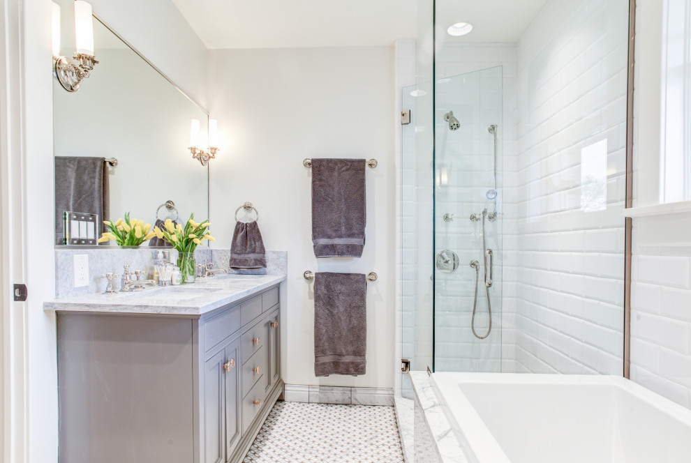 Design ideas for a mid-sized traditional master bathroom in Denver with marble benchtops, a hinged shower door, a double vanity, a built-in vanity, recessed-panel cabinets, grey cabinets, a drop-in tub, a corner shower, white tile, white walls, mosaic tile floors, an undermount sink, white floor and white benchtops.