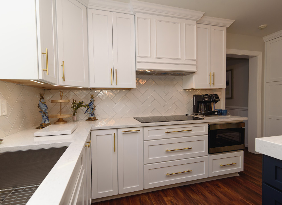 Inspiration for a mid-sized transitional galley brown floor and medium tone wood floor eat-in kitchen remodel in Baltimore with shaker cabinets, white cabinets, quartz countertops, white backsplash, subway tile backsplash, stainless steel appliances, an island, white countertops and an undermount sink