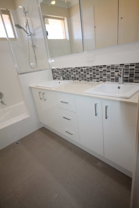Photo of a contemporary bathroom in Perth with white cabinets, an open shower and white walls.